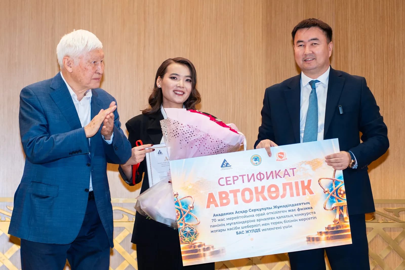 Обладательница Гран-при с цветами и сертификатом на автомобиль, рядом аплодирует академик